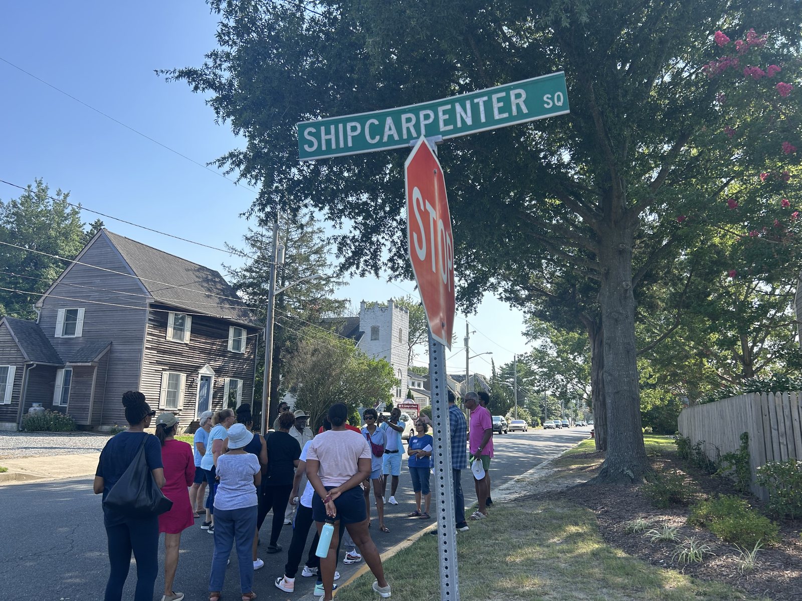 Group walking past Shipcarpenter Square street sign in Lewes